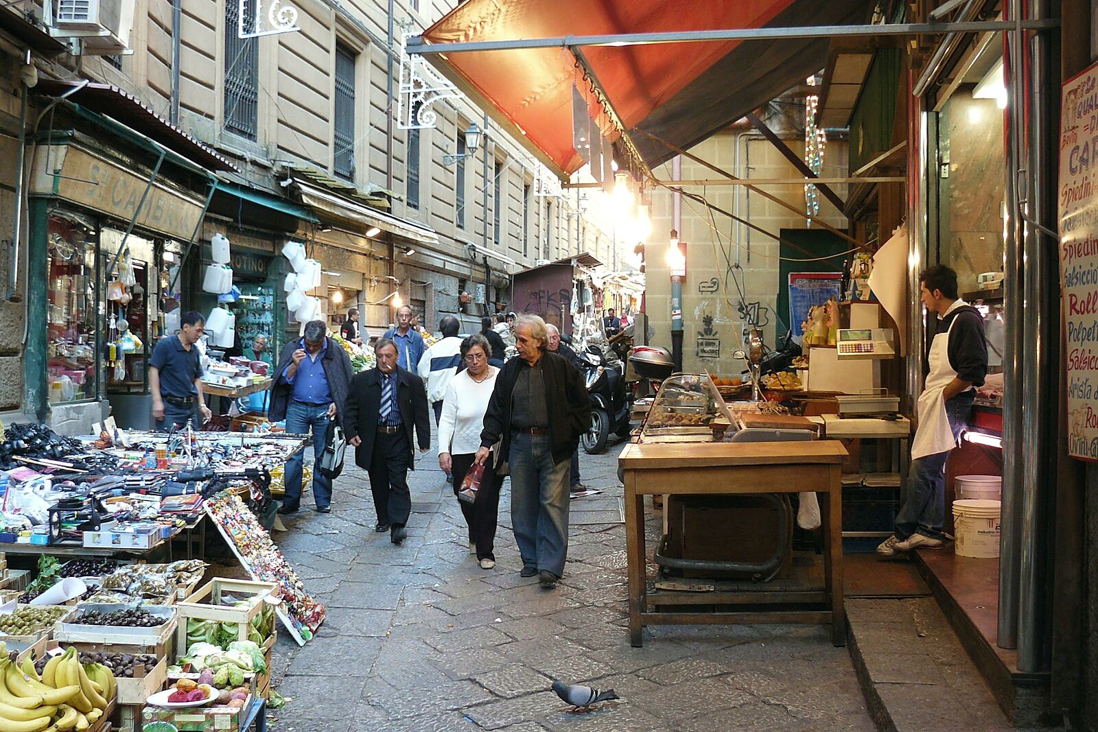 Una via di mercato con le bancarelle e la gente che passa