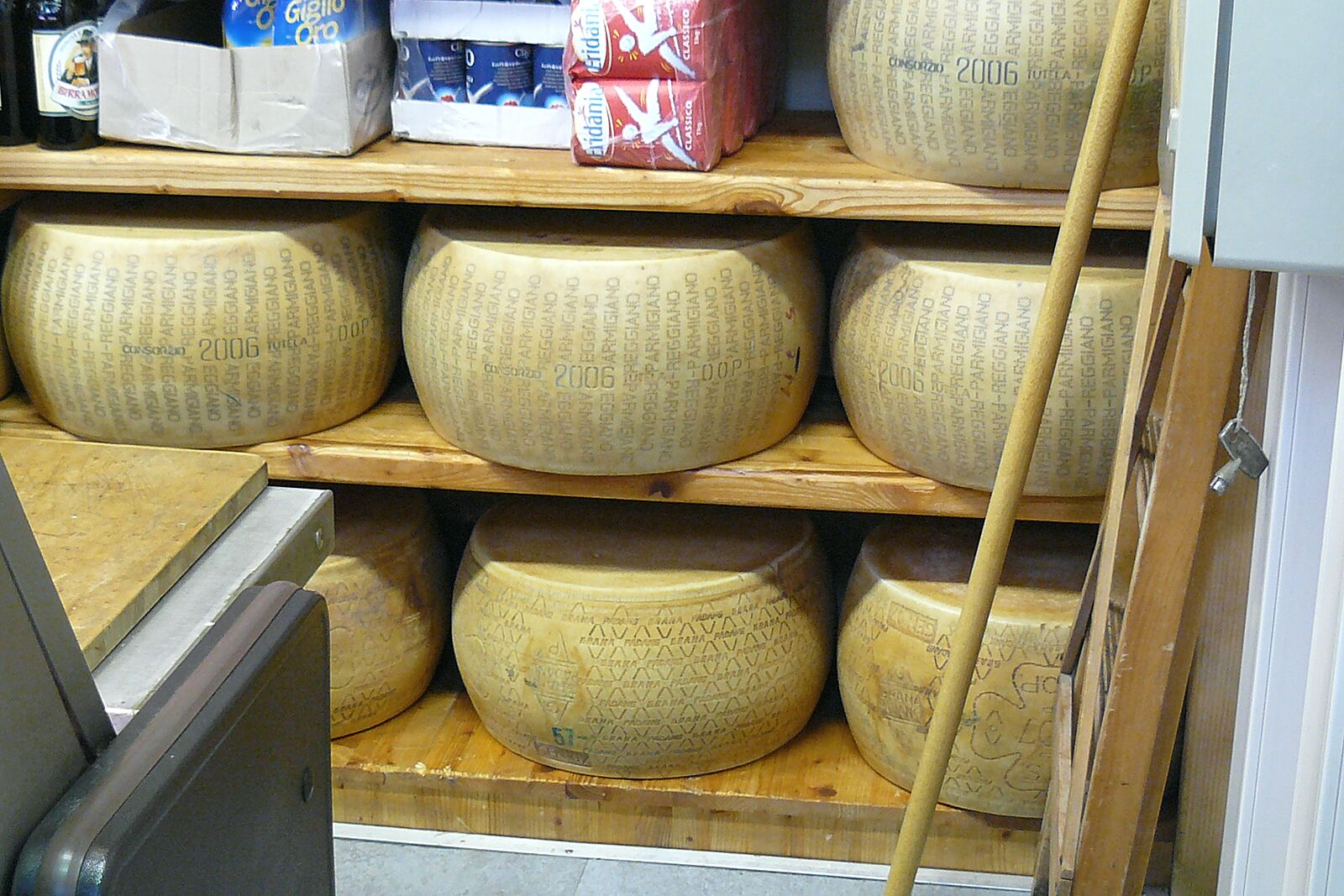 Forme di parmigiano sugli scaffali di una bottega