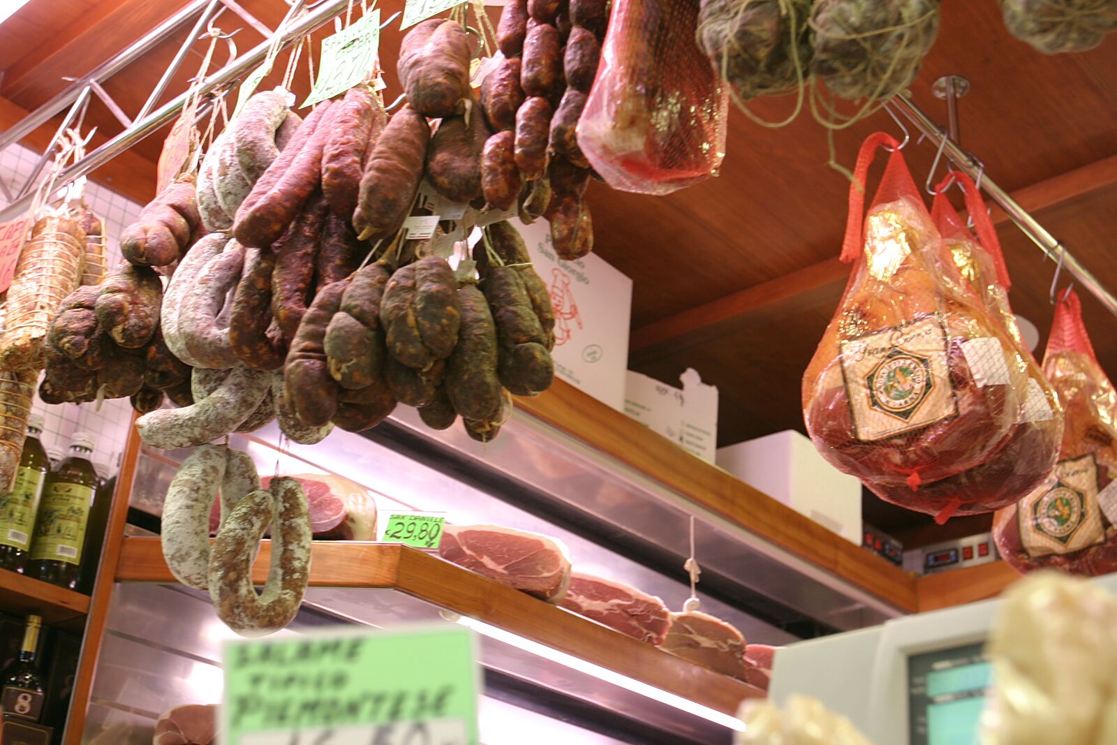 Salumi appesi sopra il banco di una gastronomia